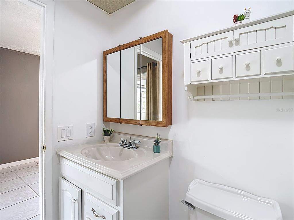 9171 Vicksburg Road Spring Hill, FL 34608 - Photo 23 of 55 a bathroom with a sink a toilet and mirror