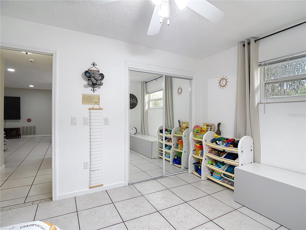 9171 Vicksburg Road Spring Hill, FL 34608 - Photo 28 of 55 a room with furniture a rug and a chandelier