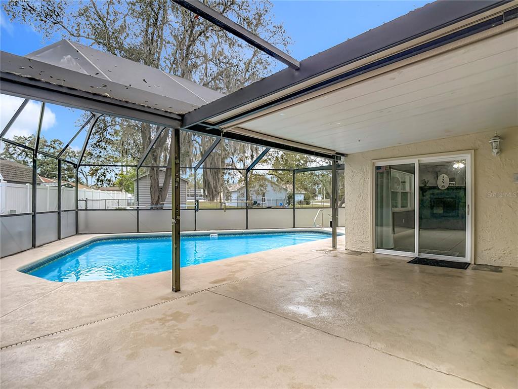 9171 Vicksburg Road Spring Hill, FL 34608 - Photo 32 of 55 a view of an empty room with wooden floor and a floor to ceiling window