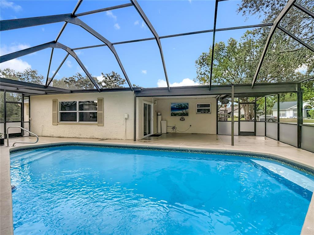 9171 Vicksburg Road Spring Hill, FL 34608 - Photo 36 of 55 a view of a patio with a table and chairs under an umbrella