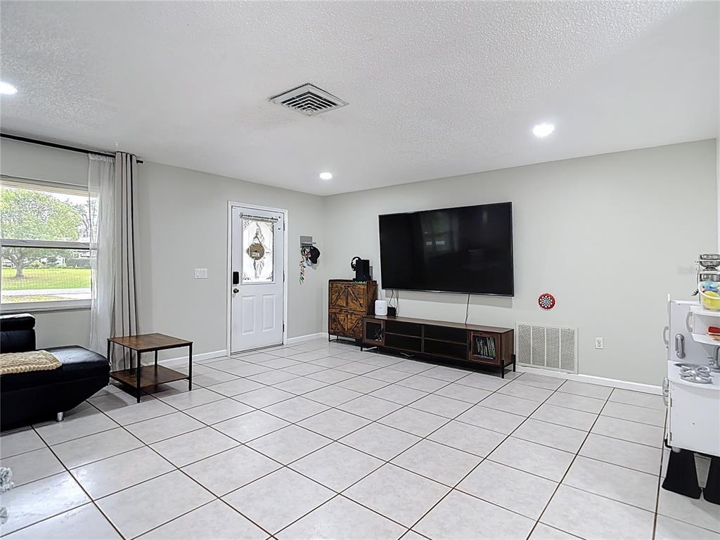 9171 Vicksburg Road Spring Hill, FL 34608 - Photo 5 of 55 a living room with furniture and a flat screen tv