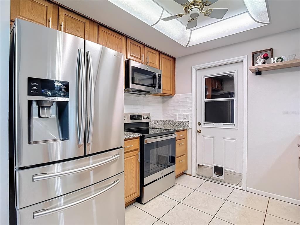 9171 Vicksburg Road Spring Hill, FL 34608 - Photo 9 of 55 a kitchen with stainless steel appliances granite countertop a refrigerator and a stove top oven