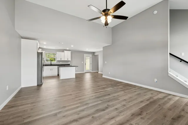 a view of an empty room with a window and wooden floor