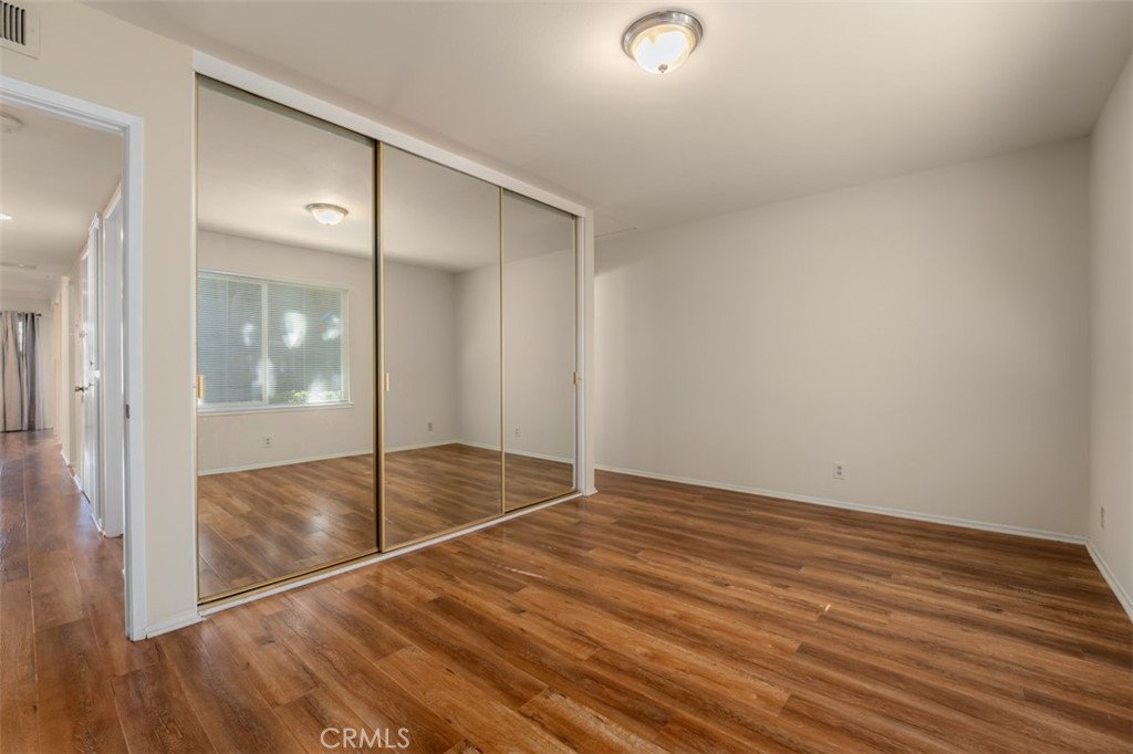 10454 Rio Grande Court Fountain Valley, CA 92708 - Photo 10 of 17 an empty room with wooden floor and mirror