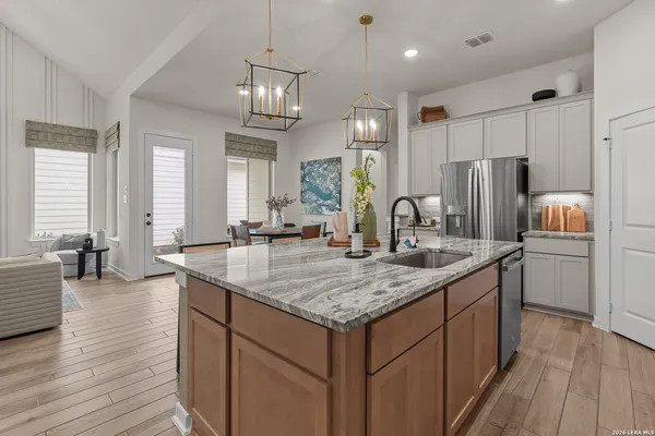 a kitchen with center island wooden floor center island and stainless steel appliances