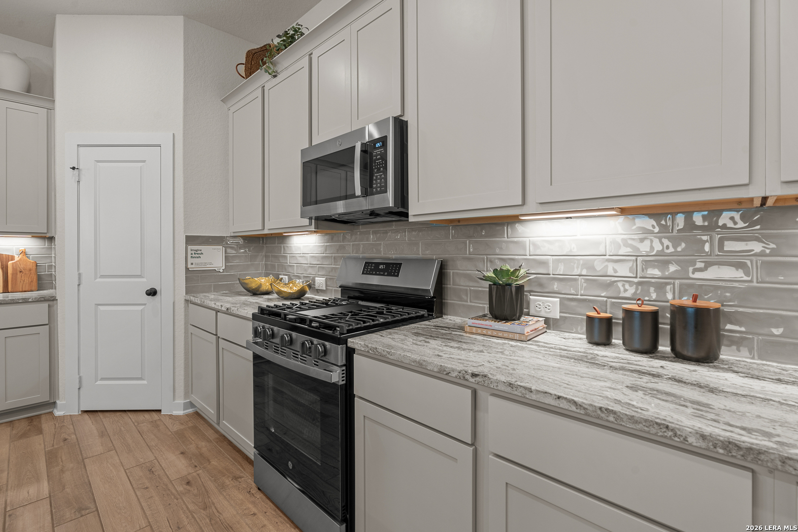 9435 Hidden Stone Schertz, TX 78154 - Photo 26 of 41 a kitchen with granite countertop white cabinets stainless steel appliances and sink