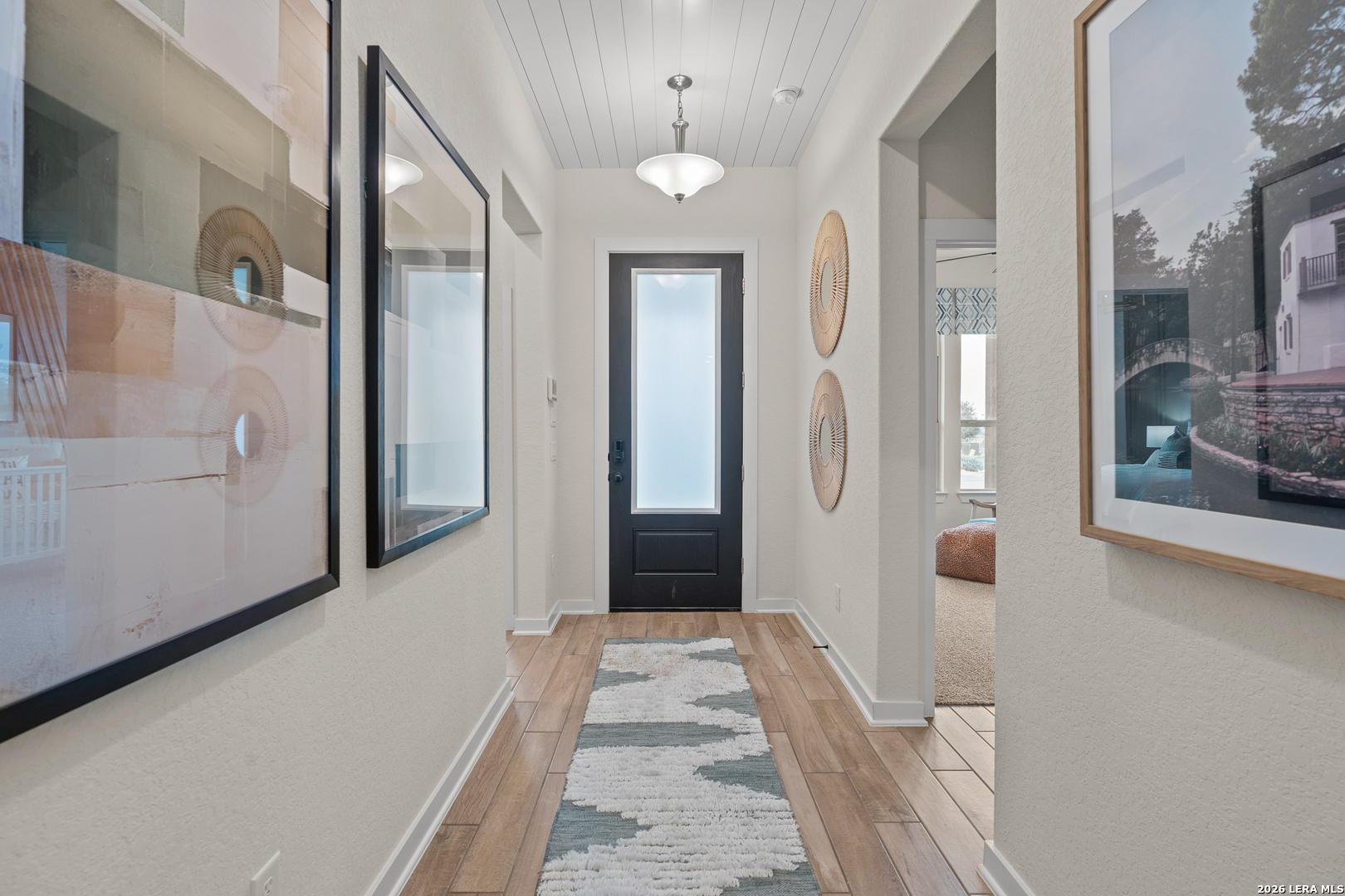 9435 Hidden Stone Schertz, TX 78154 - Photo 5 of 41 view of a hallway with wooden floor and staircase