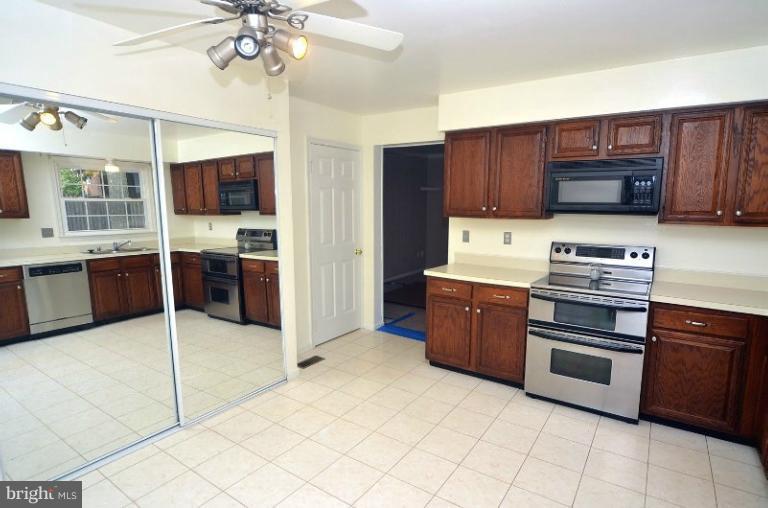 2207 Aventurine Way Silver Spring, MD 20904 - Photo 16 of 27 a kitchen with stainless steel appliances a stove a sink and a microwave