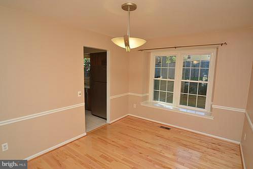2207 Aventurine Way Silver Spring, MD 20904 - Photo 17 of 27 a view of an empty room with a window and wooden floor