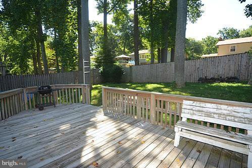 2207 Aventurine Way Silver Spring, MD 20904 - Photo 24 of 27 a view of a deck with wooden floor barbeque oven and trees