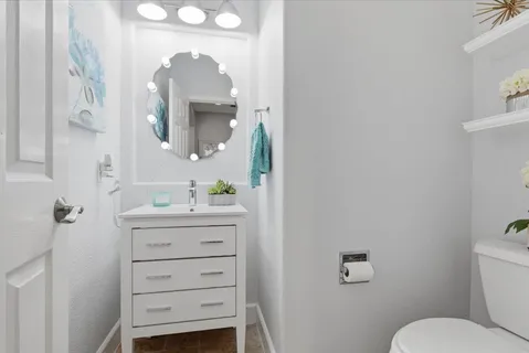 a bathroom with a toilet a sink a vanity and mirror