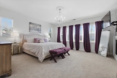 a spacious bedroom with a bed and a chandelier