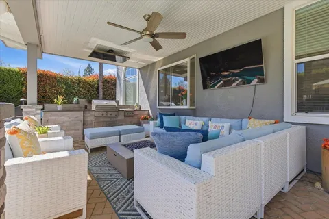a living room with couch a flat screen tv and a large window