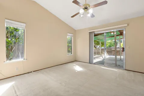 an empty room with windows and fan