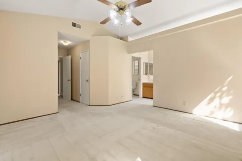 an empty room with a ceiling fan and a window