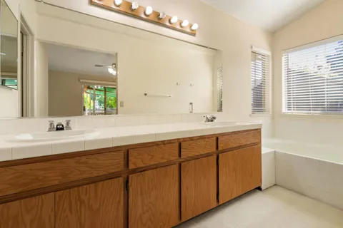 a spacious bathroom with double vanity and a mirror