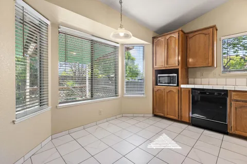 a view of a kitchen with a sink dishwasher and a fireplace