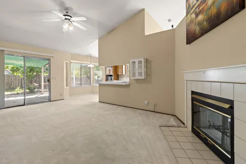 a view of an empty room with a fireplace and a window
