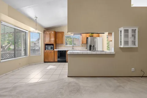 a living room with a large window and kitchen view