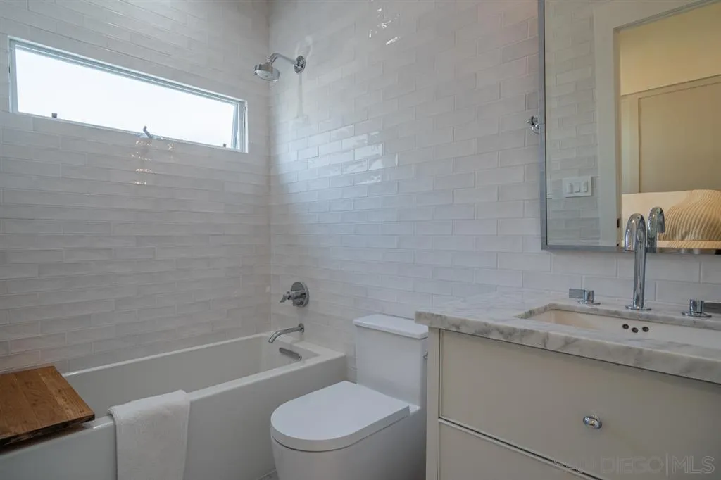 370 Glorietta Boulevard Coronado, CA 92118 - Photo 18 of 25 a bathroom with a granite countertop sink a toilet and shower