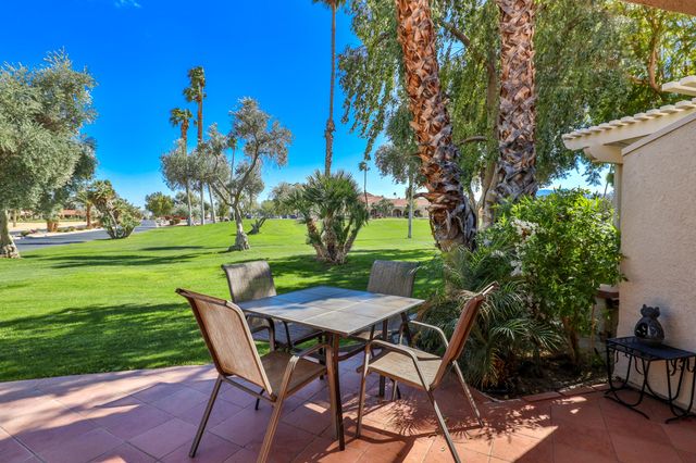 a view of a wooden dinning table and chairs in the garden