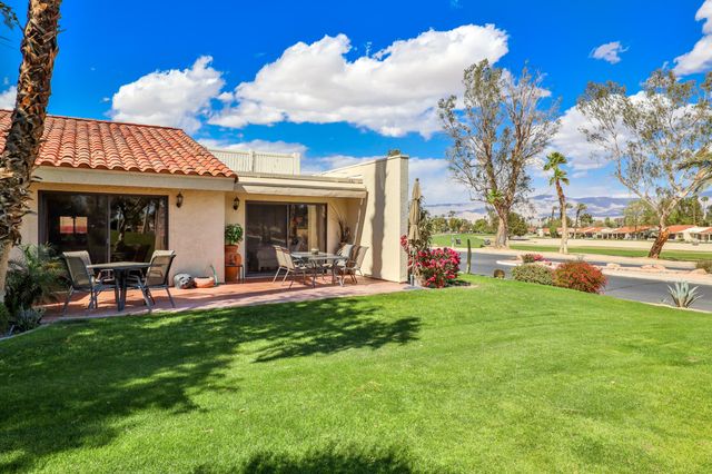 a view of a house with backyard porch and sitting area