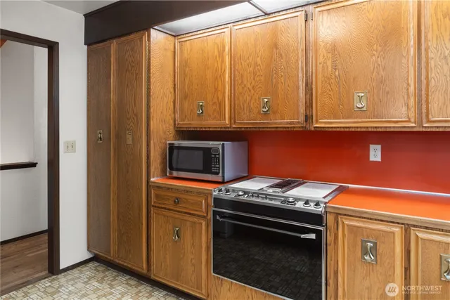 a kitchen with stainless steel appliances granite countertop a stove a sink and a refrigerator with wooden cabinets