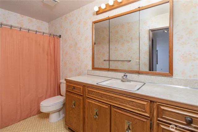 a bathroom with a granite countertop sink toilet and shower