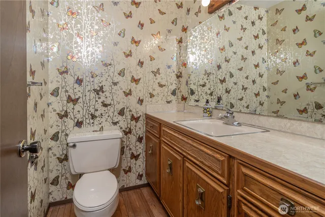 a bathroom with a granite countertop toilet sink and mirror