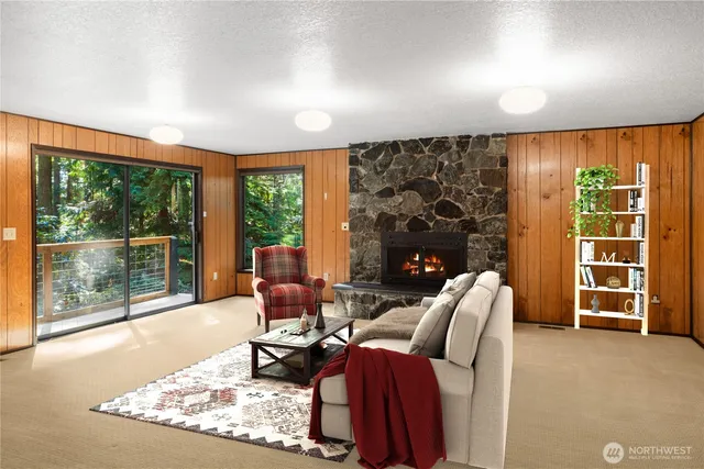 a living room with furniture a flat screen tv and a floor to ceiling window