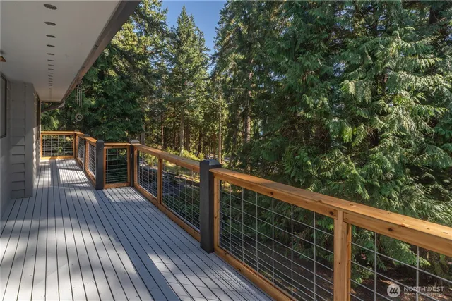 a balcony with wooden floor and trees