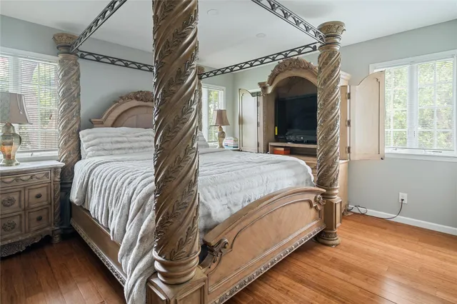 a view of a bedroom with wooden floor and furniture