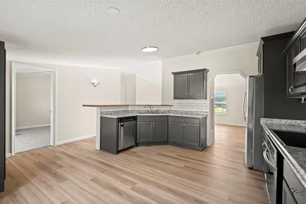 a kitchen with stainless steel appliances granite countertop a kitchen island a stove and a refrigerator