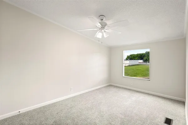 an empty room with a window and a fan