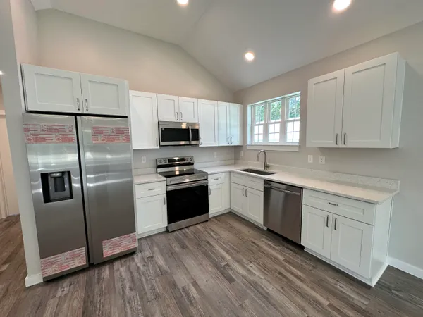 a kitchen with a refrigerator cabinets and wooden floor