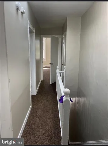 a view of hallway with furniture and stairs