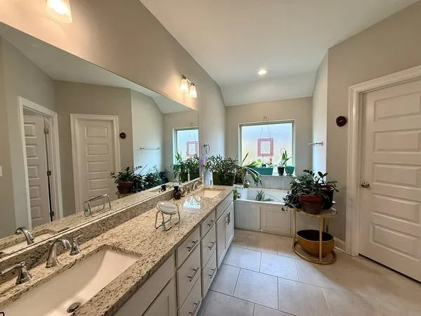 a large white kitchen with a sink and cabinets