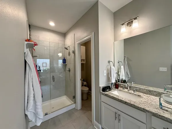 a bathroom with a shower sink and mirror