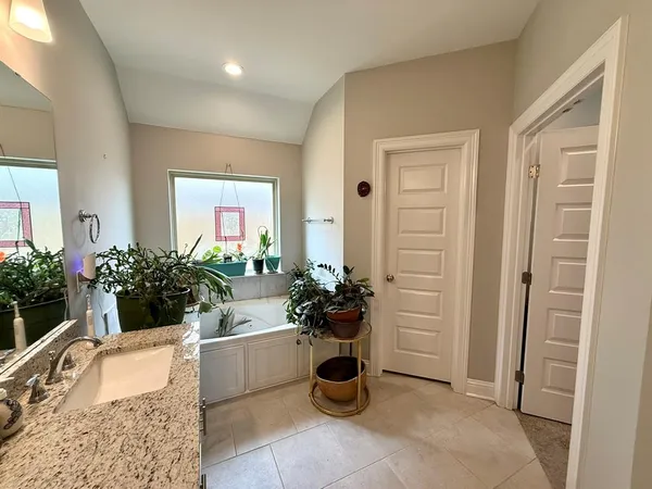 a bathroom with a tub sink and mirror
