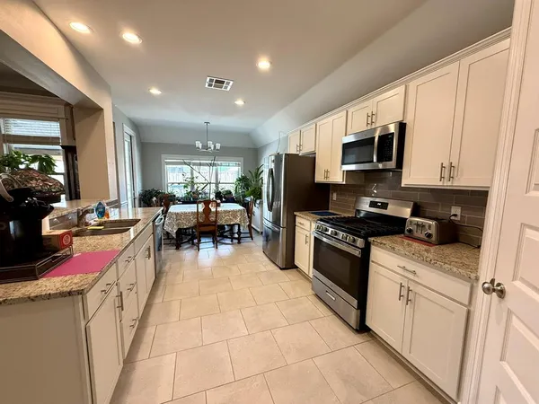 a kitchen with stainless steel appliances granite countertop a stove and cabinets