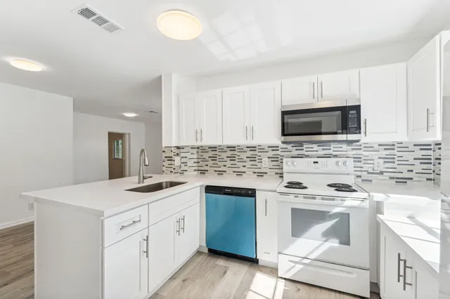 a kitchen with a sink stove and microwave