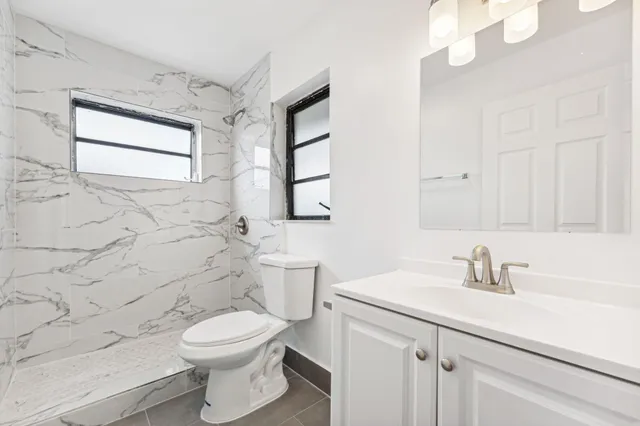 a bathroom with a sink a toilet and mirror