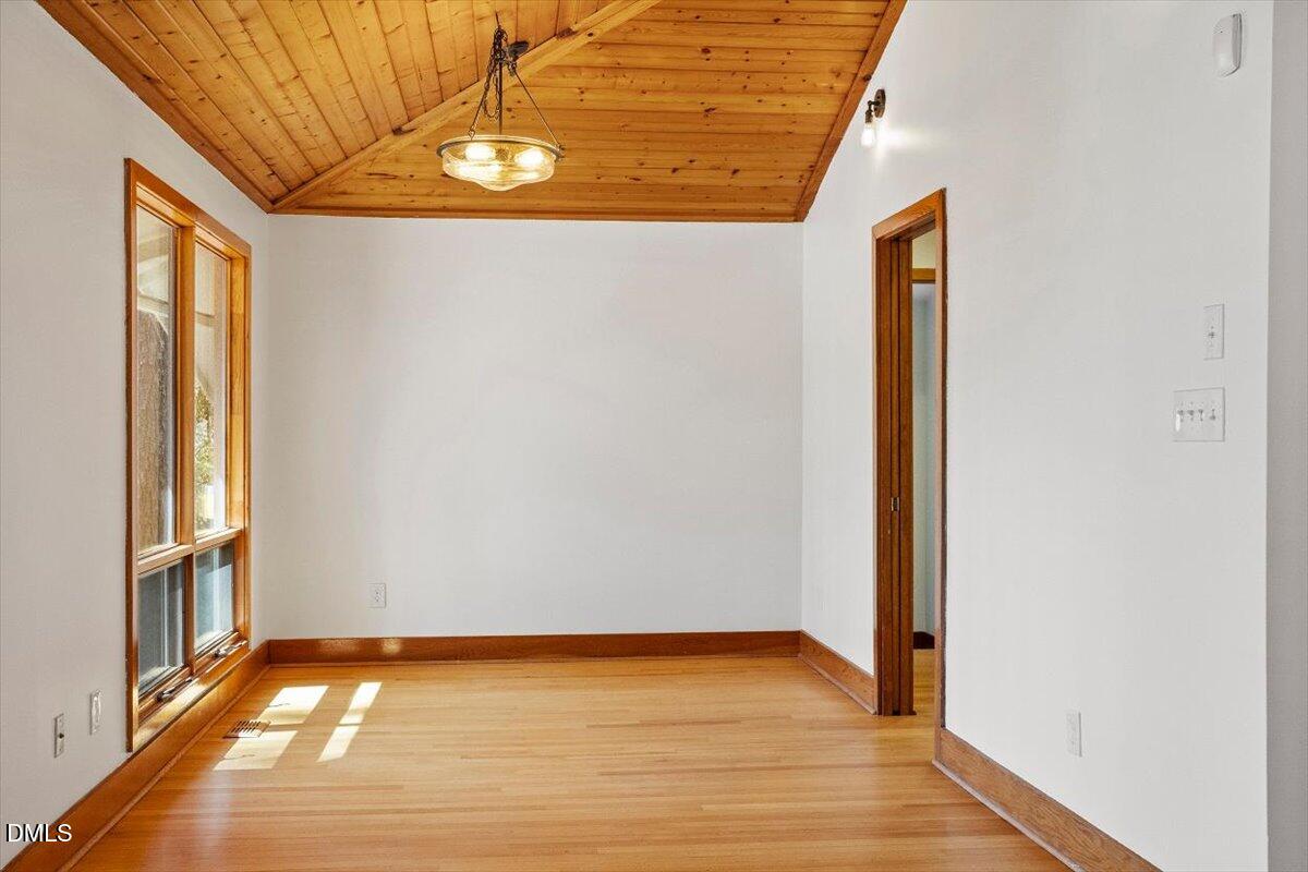 4805 Rembert Drive Raleigh, NC 27612 - Photo 12 of 45 a view of an empty room with wooden floor and a window