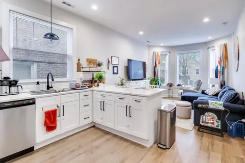 a large white kitchen with a lot of white cabinets and stainless steel appliances