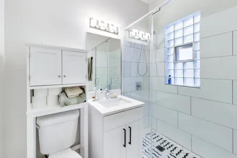 a bathroom with a sink a toilet and shower