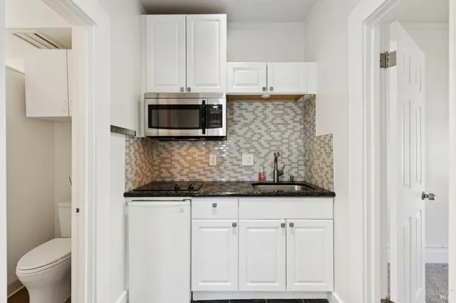 a kitchen with white cabinets and stainless steel appliances