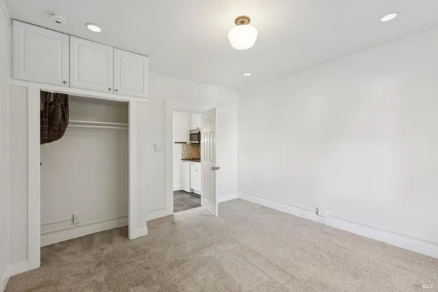 an empty room with kitchen walk in closet and windows