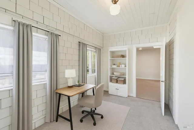 a view of a workspace with furniture and a window