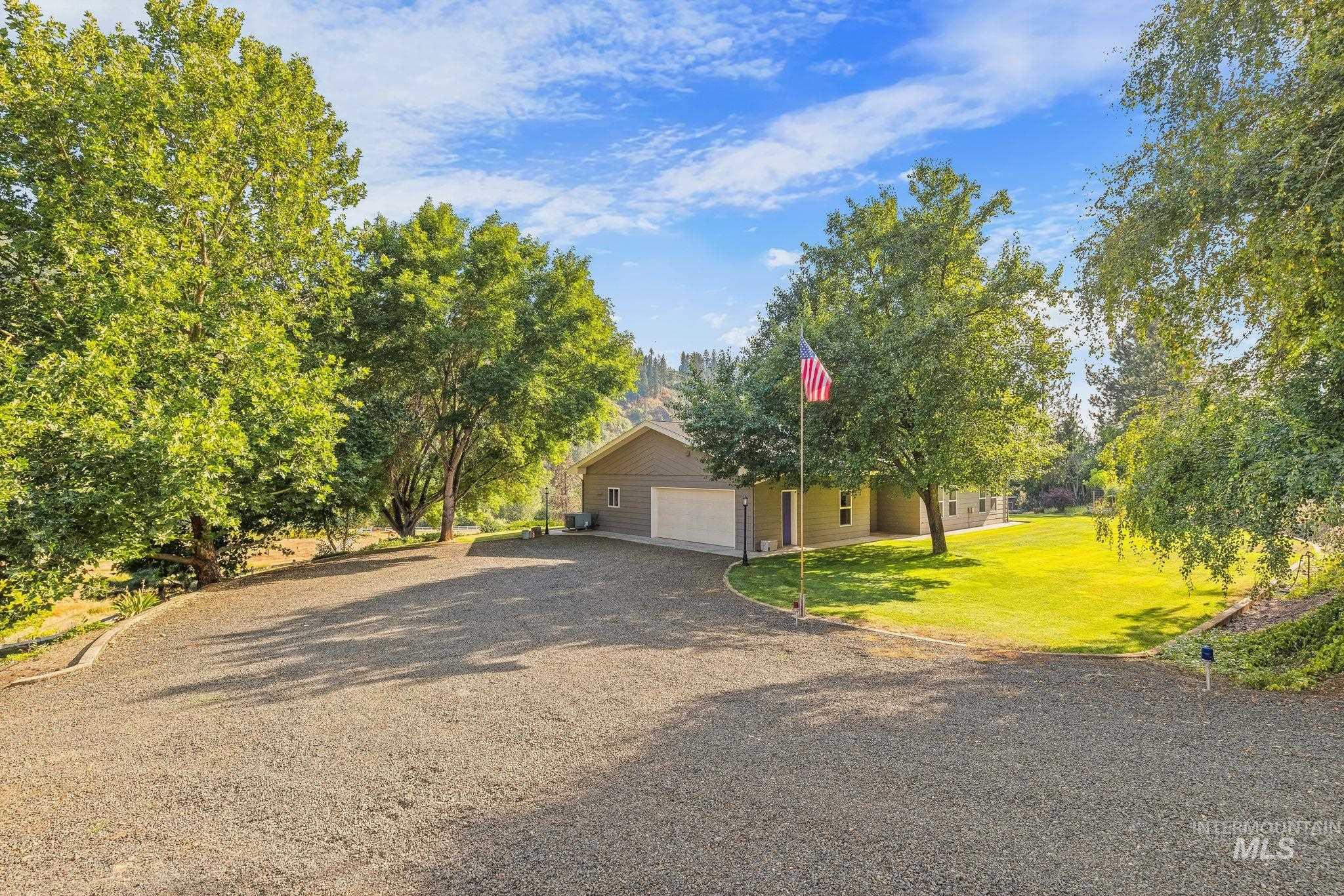 1091 Cedar Ridge Road Kendrick, ID 83537 - Photo 1 of 48 Property featuring a gravel driveway, mature trees, and a spacious green lawn