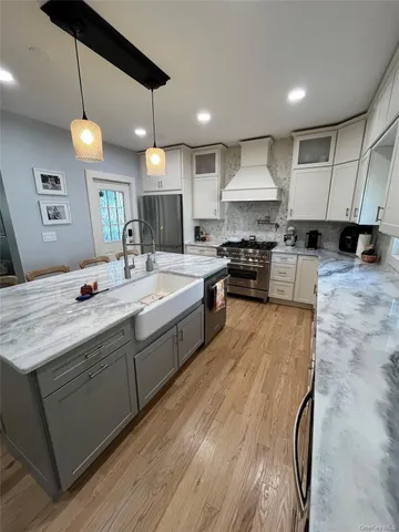 a kitchen with kitchen island granite countertop a sink stainless steel appliances and white cabinets